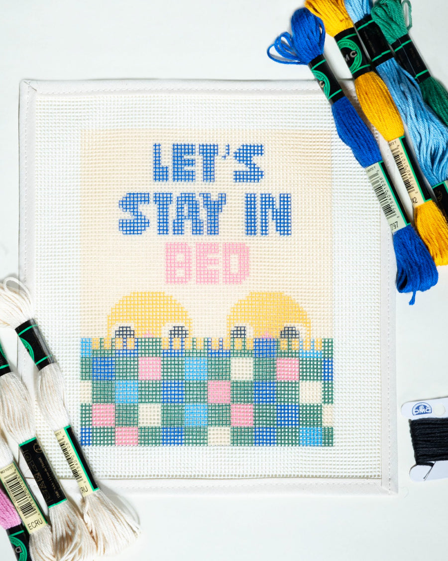 'let's stay in bed' typography and people graphic needlepoint kit with embroidery yarn and instructions