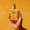 model holding 2.9 fl. oz vacation shimmer oil with spf 30