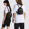 models wearing black mini backpack with skateboard 'vans off the wall' patch and front zip pocket