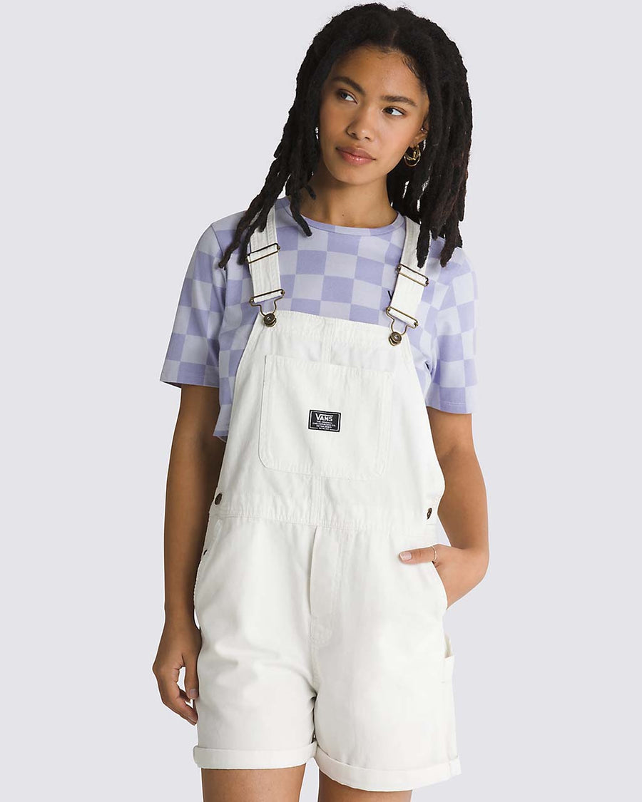 model wearing white cotton short overalls with patch front pocket, adjustable straps, side pockets and vans logo patch