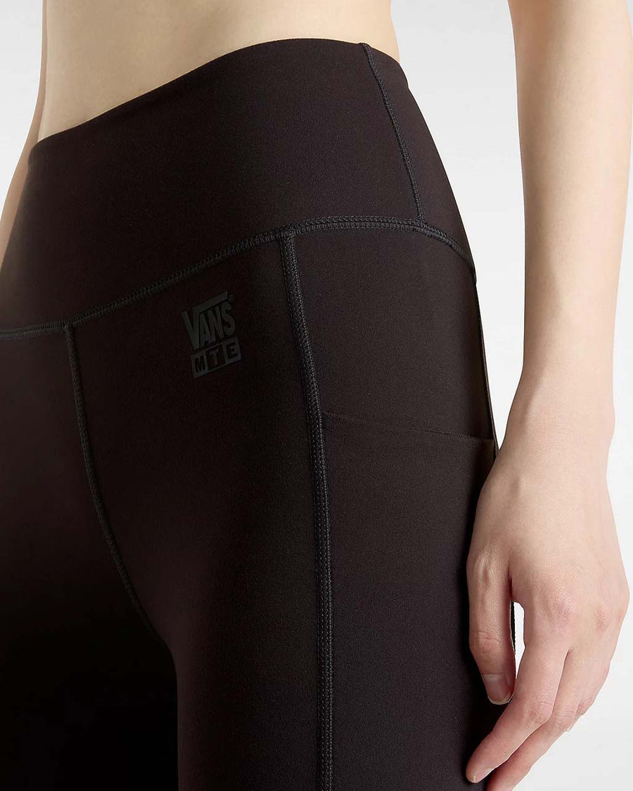 up close of model wearing black active leggings with vans logo and side pockets