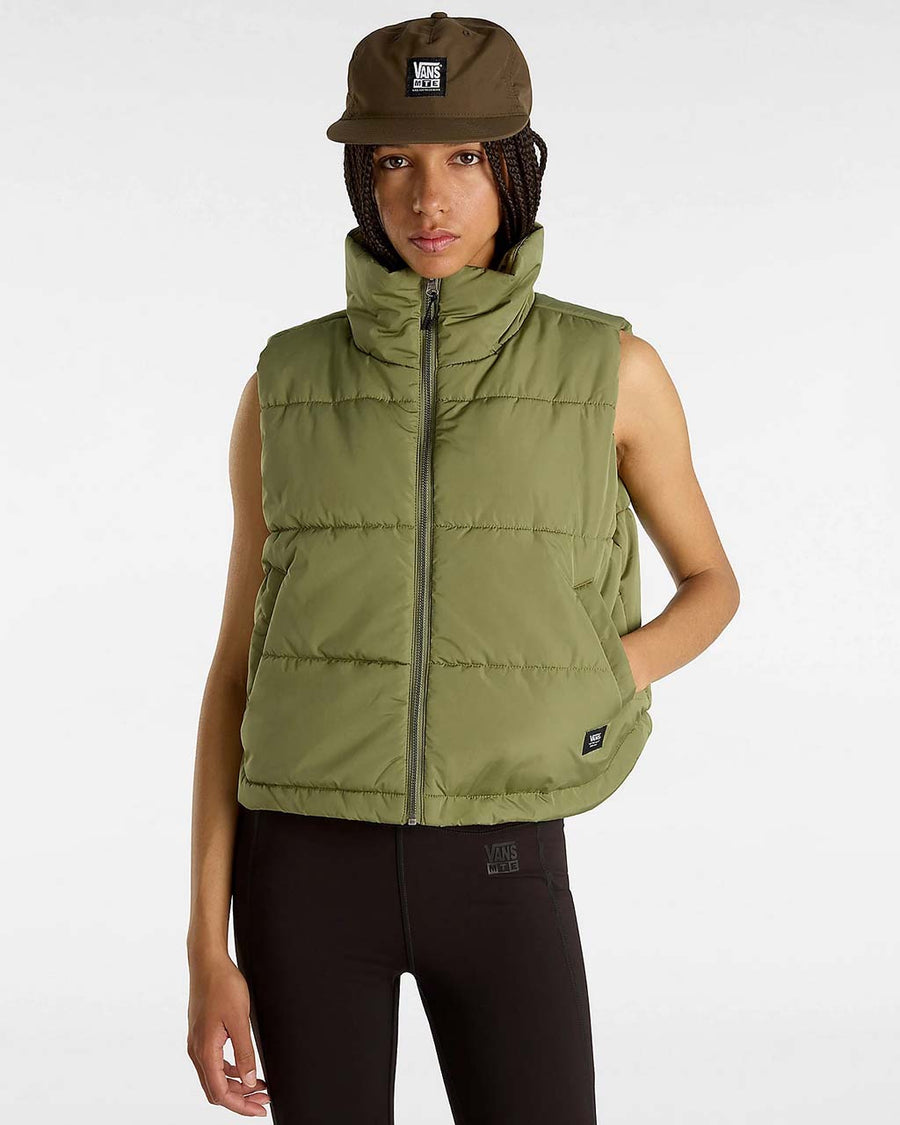 model wearing green puffer vest with high neck and side pockets