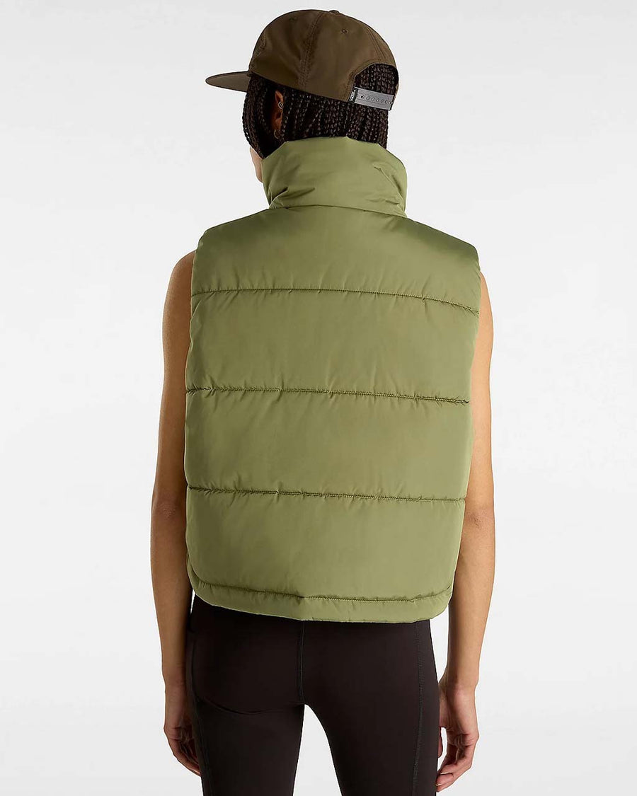 back view of model wearing green puffer vest with high neck and side pockets