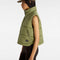 side view of model wearing green puffer vest with high neck and side pockets