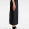 side view of model wearing black midi skirt with elastic waist, button front, and cargo pockets