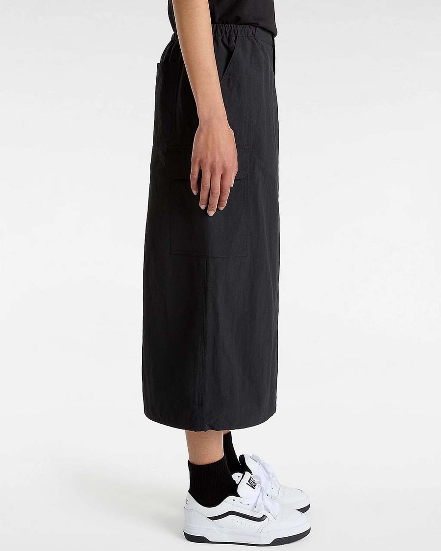 side view of model wearing black midi skirt with elastic waist, button front, and cargo pockets