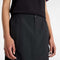 up close of model wearing black midi skirt with elastic waist, button front, and cargo pockets