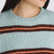 up close of model wearing grey oversized sweater with burgundy and orange stripes