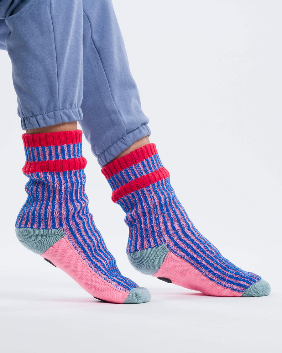 model wearing pink and blue ribbed socks with pink and grey bottom with non-stick bottoms