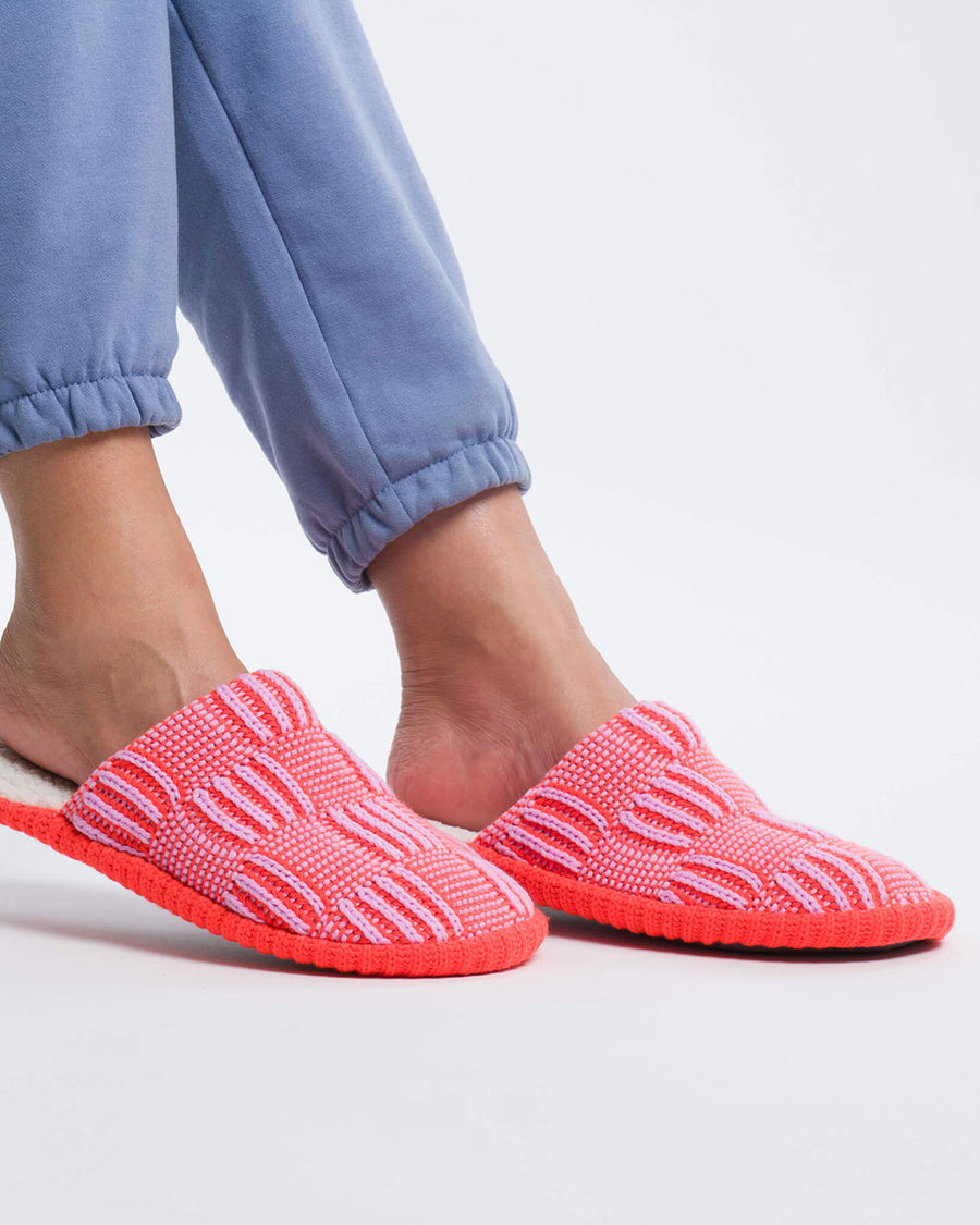 model wearing pink checkered slip on slippers with fuzzy interior