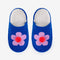 top view of blue slip on slippers with pink flower and pom detail and fuzzy interior