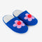 blue slip on slippers with pink flower and pom detail and fuzzy interior