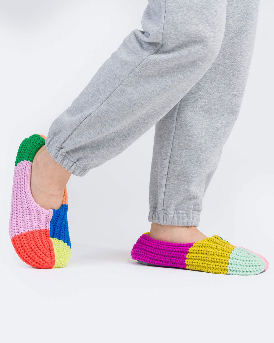 model wearing mismatched slippers with fuzzy interior