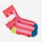 fuzzy interior of pink striped socks with yellow and blue trim and non-slip bottom