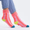 model wearing pink striped socks with yellow and blue trim and non-slip bottom