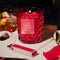 red bubble standard candle with cherry rose scent on a tray surrounded by cherries on a table with bedazzled lighter and white tray