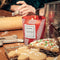 red and white striped candy cane scented candle next to holiday cookies