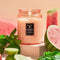 large 18oz. watermelon scented candle in a coral embossed vessel surrounded by watermelons and lime