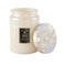 large 18oz. santal vanilla scented candle in a cream embossed vessel with lid off