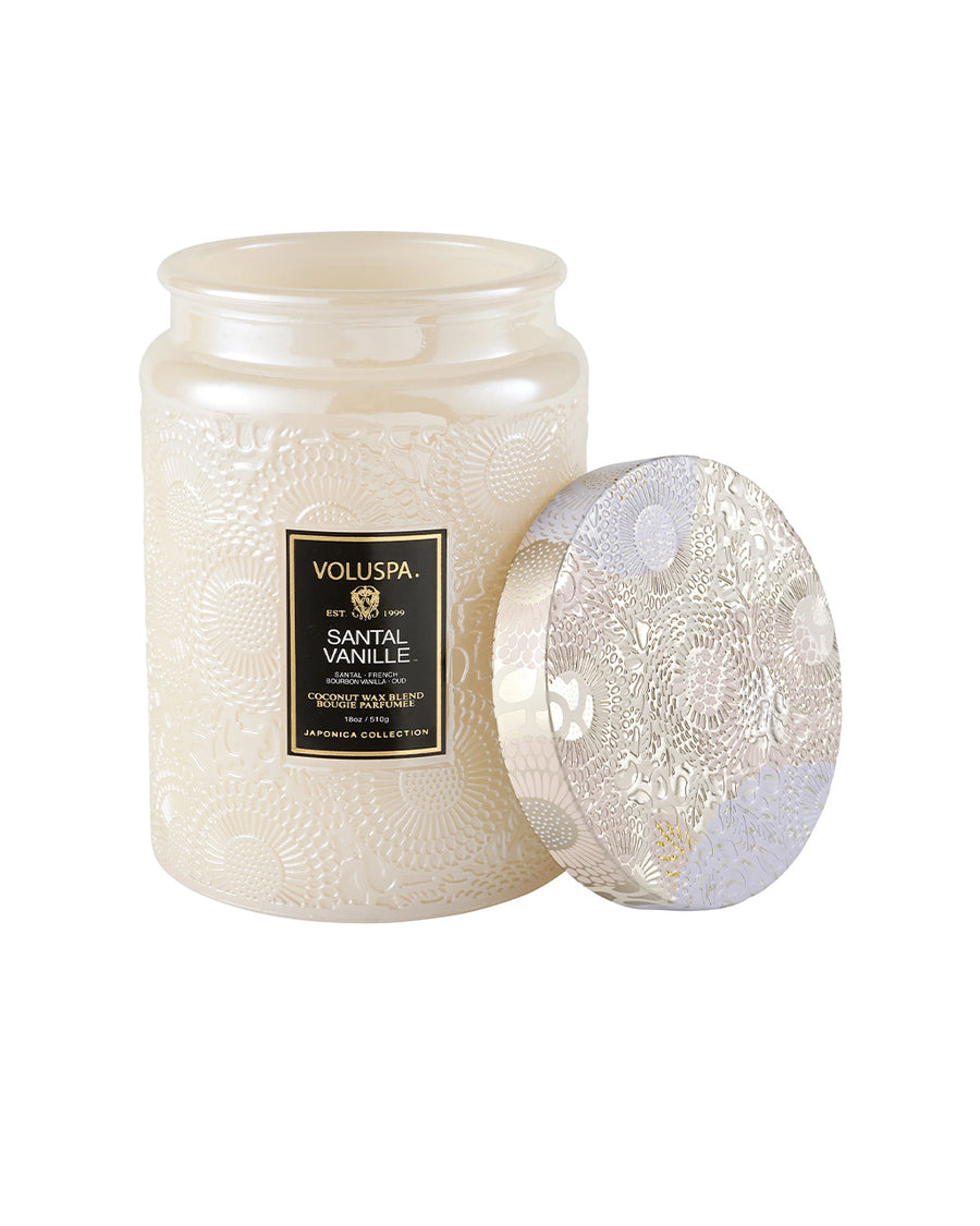 large 18oz. santal vanilla scented candle in a cream embossed vessel with lid off