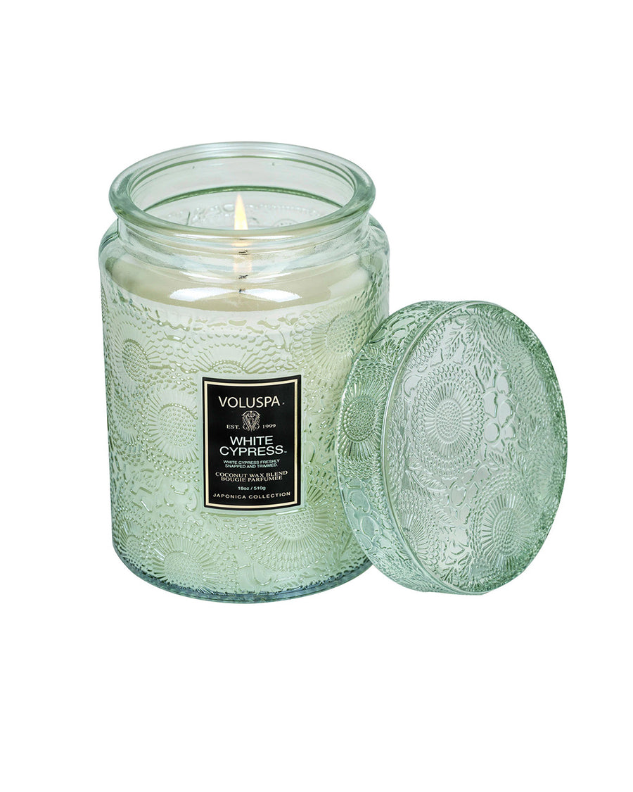 lit large 18oz. white cypress scented candle in a mint embossed vessel