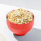 red silicone reusable popcorn popper with popcorn inside