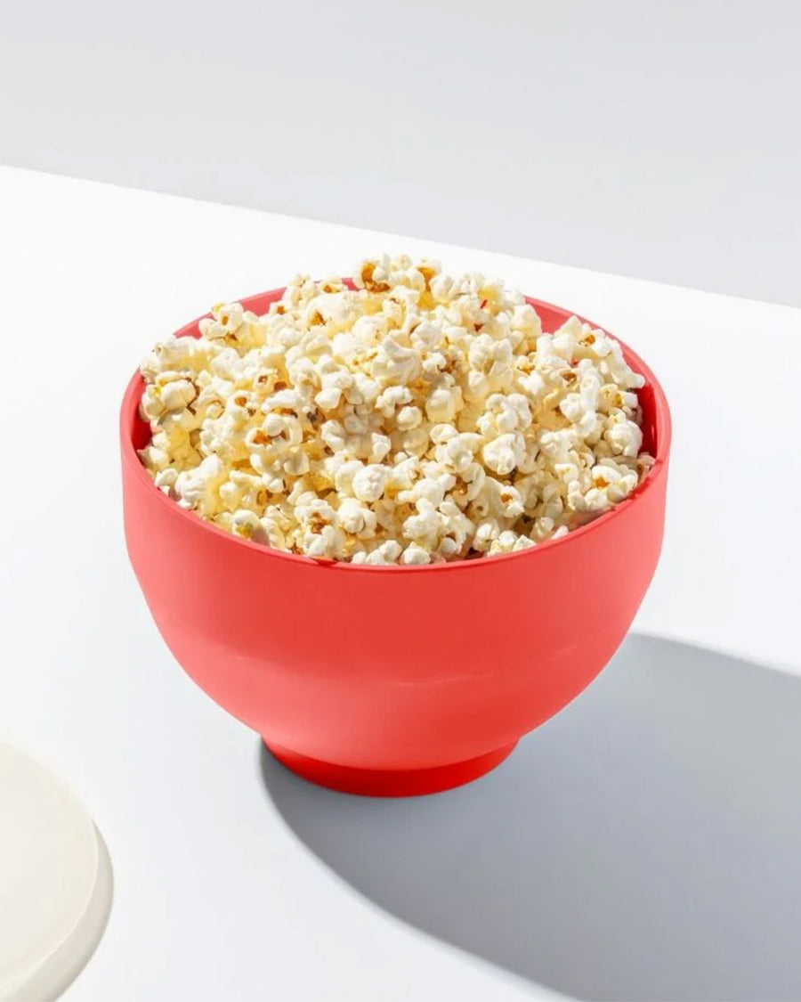 red silicone reusable popcorn popper with popcorn inside