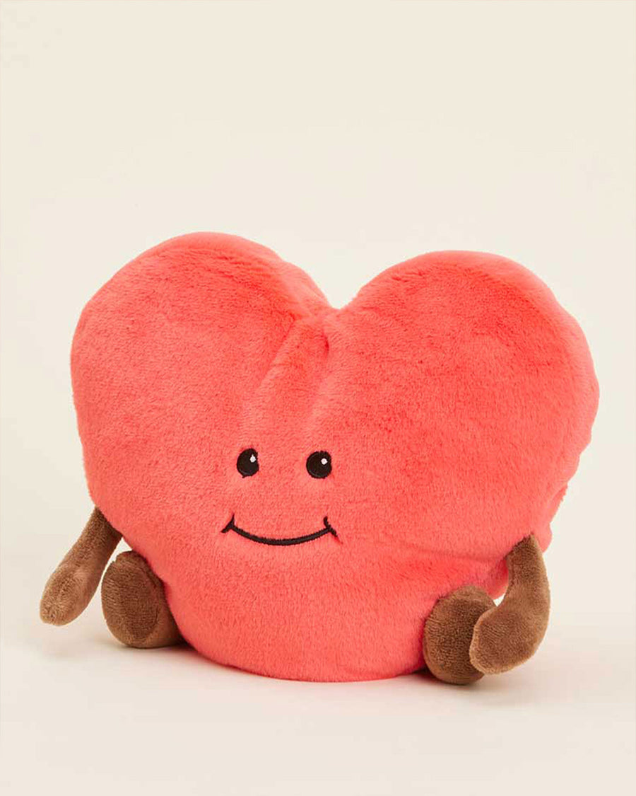 side view of pink heart-shaped plush toy with brown arms and legs