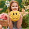 model holding smiley shaped microwavable heating plush