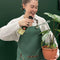 model wearing green apron with leather straps and front pockets