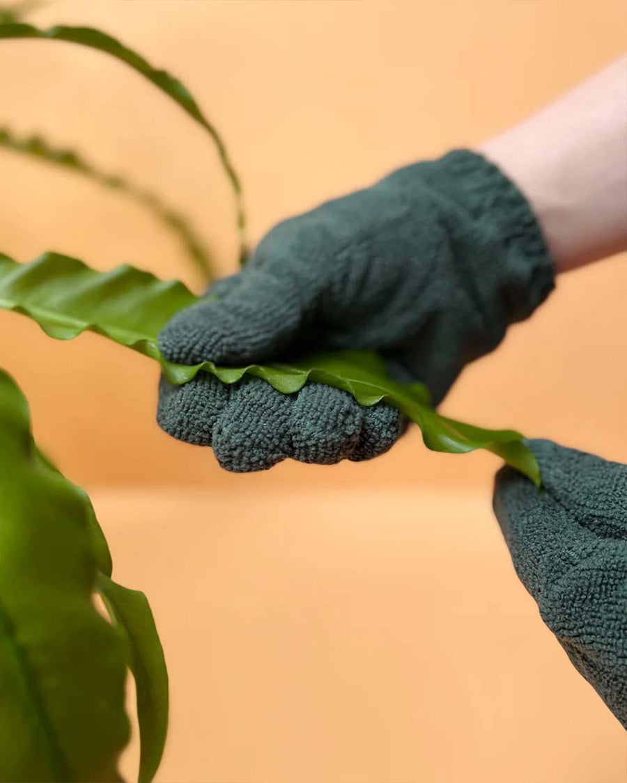 model wearing dark green leaf cleaning gloves