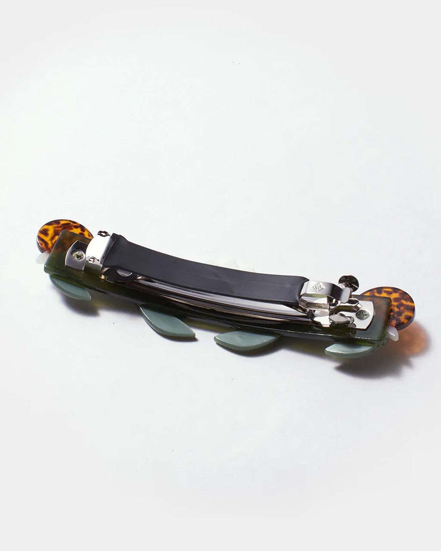 under side of green french barrette with tortoise shell snail details