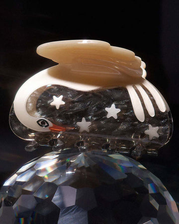 white bird hair claw with brown ground and white star detail on a disco ball