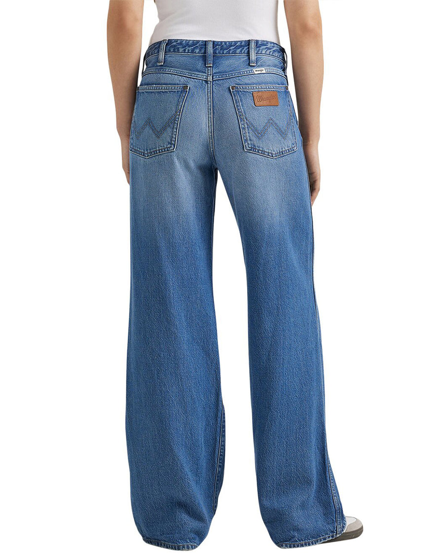 back view of model wearing wide leg denim with a medium wash