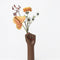 hand vase with flowers sticking out of the hands