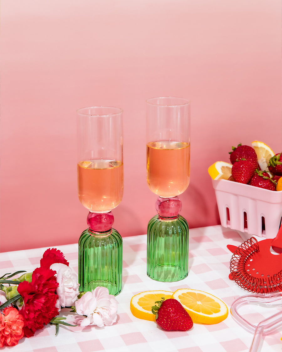 set of 2 bar glasses with green base and pink center detail on table