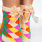 model wearing colorful checkerboard chenille grip socks with removable bow detail