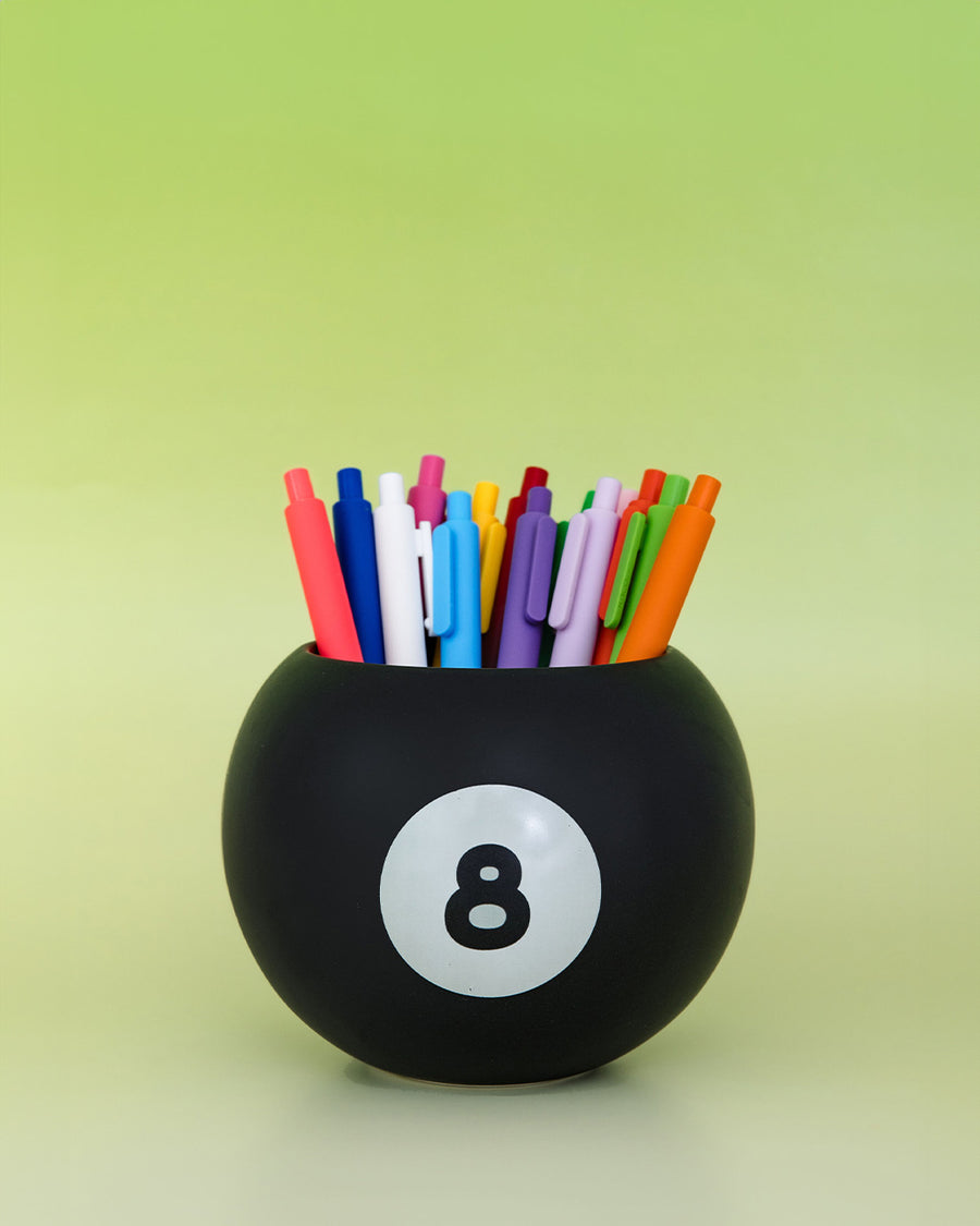 black magic 8 ball shaped vase with pens inside