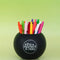 black magic 8 ball shaped vase with pens inside and 'the moment is now' on the back