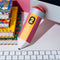 yellow and pink pencil shaped de-stress ball on a desk