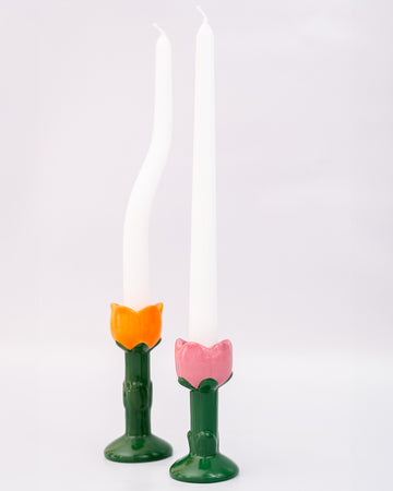 orange and pink tulip candle holder with white taper candles inside