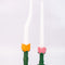 orange and pink tulip candle holder with white taper candles inside