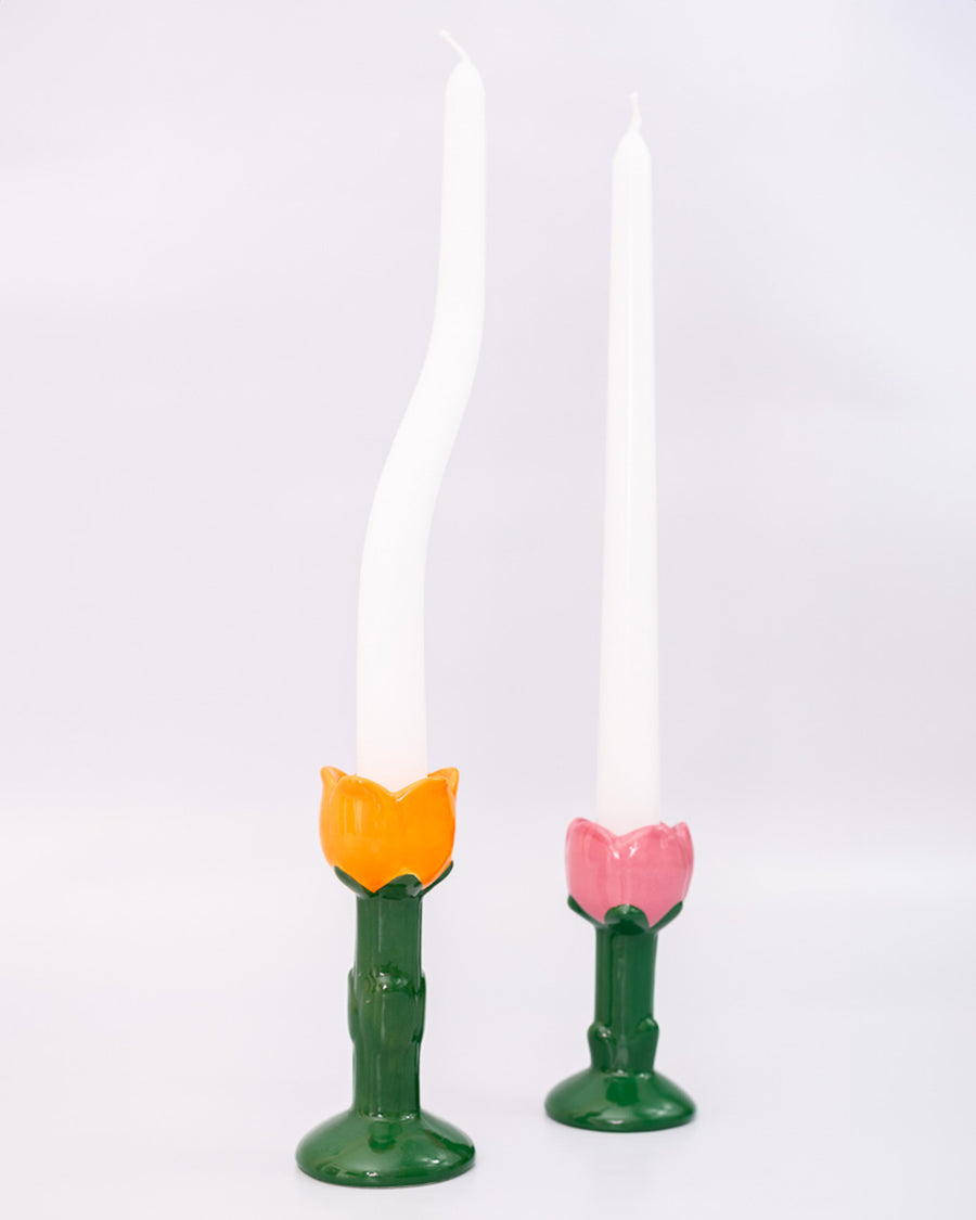 orange and pink tulip candle holder with white taper candles inside