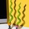 orange and pink tulip candle holder with green squiggle candles in them