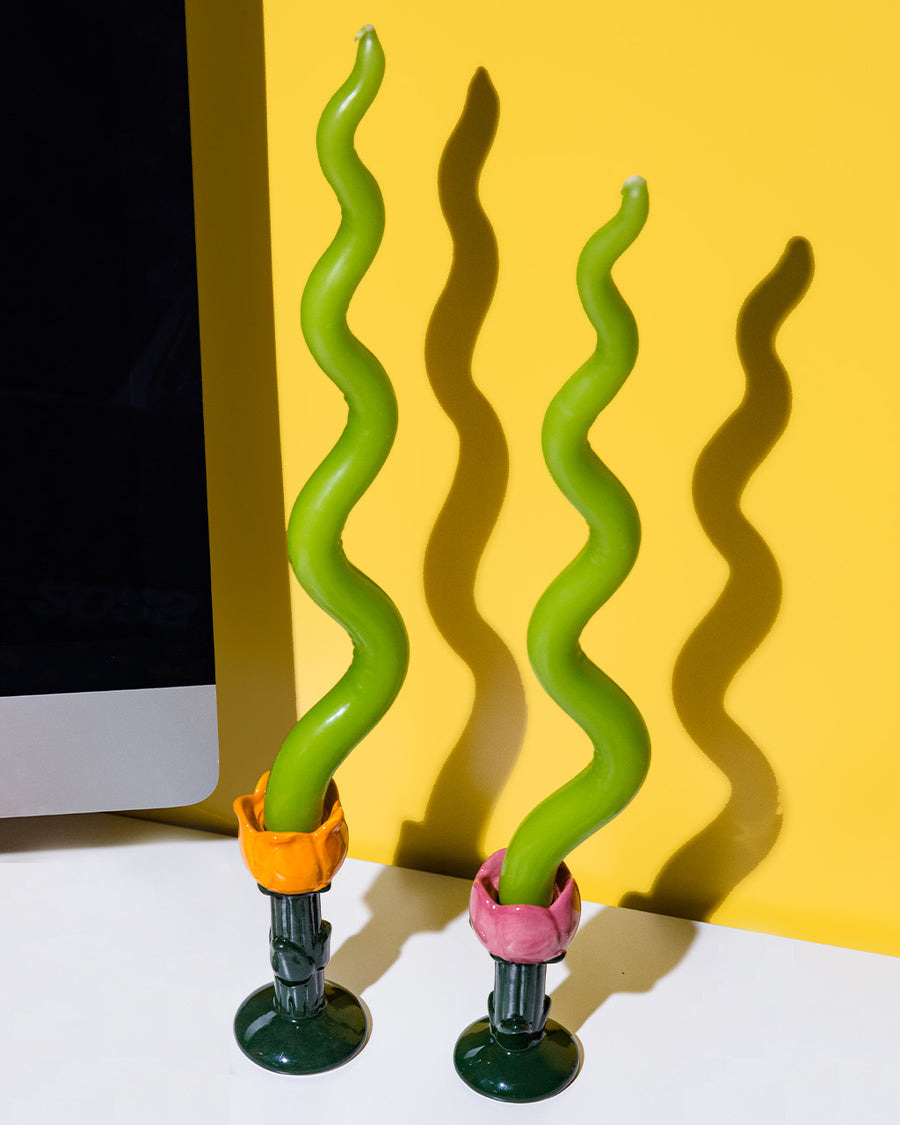 orange and pink tulip candle holder with green squiggle candles in them