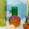 pink cherry shaped carafe with green lid/cup with leaf detail on a table