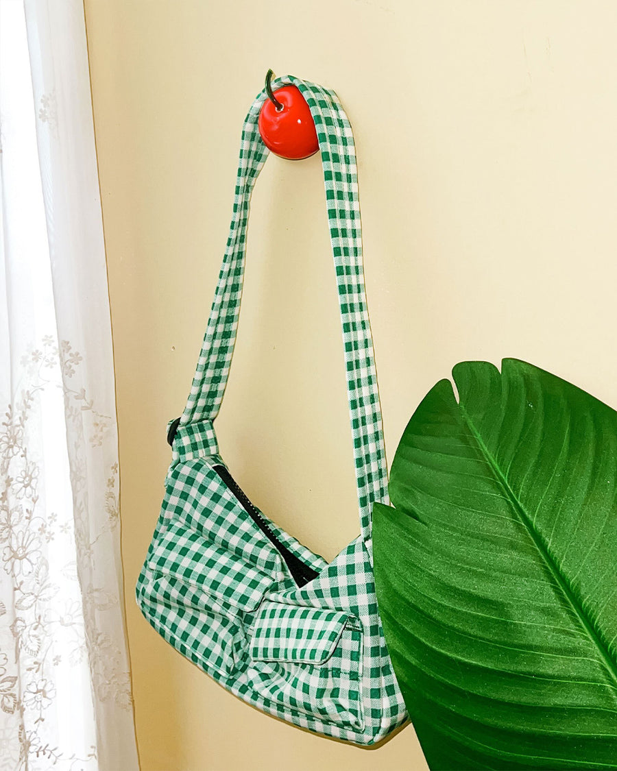 red cherry hook with green gingham purse hanging from it