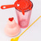 pink bar shaker with red heart top, red strainer, and yellow stirring stick with strainer on top