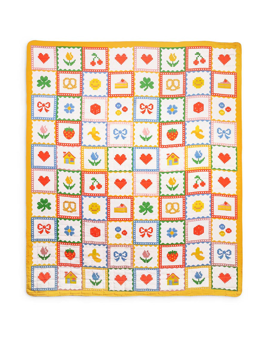 colorful patchwork quilted blanket with heart, shamrocks, pretzels, smiley faces, cakes, and bows