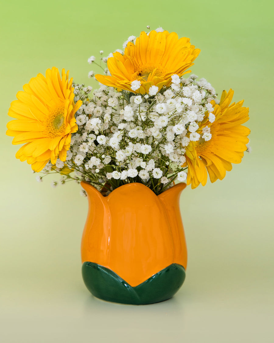 orange tulip shaped pencil holder with flowers inside